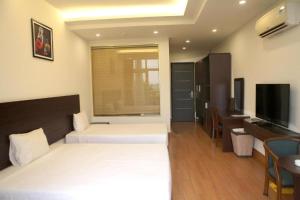 Cette chambre comprend deux lits et une télévision. dans l'établissement J&C HOTEL, à Bắc Ninh