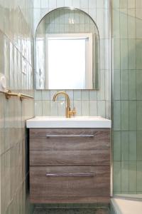 bagno con lavandino e specchio di Nets Inn Apartments - Buttes Chaumont D a Parigi