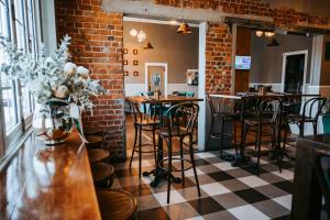 ein Zimmer mit Tischen und Stühlen und einer Ziegelwand in der Unterkunft Rix Hotel Motel in Charters Towers