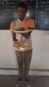 Um homem está a segurar um prato de comida. em Stonefish Inn Jambiani em Jambiani