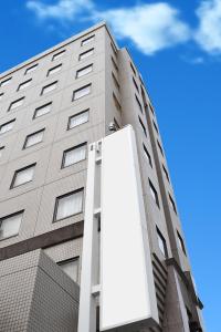 un grand bâtiment avec un grand panneau devant lui dans l'établissement 高松パークホテル, à Takamatsu
