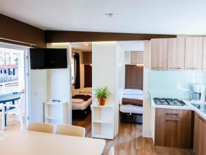 eine Küche und ein Wohnzimmer mit einem Tisch und einem Zimmer in der Unterkunft Caravan Park in Nin with Sandy Beach & Pools in Zaton