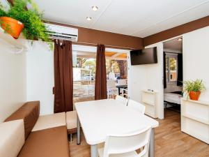 ein Wohnzimmer mit einem weißen Tisch und einer Couch in der Unterkunft Caravan Park in Nin with Sandy Beach & Pools in Zaton