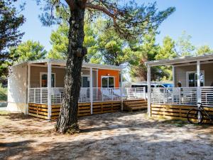 zwei modulare Häuser mit einem Baum im Vordergrund in der Unterkunft Caravan Park in Nin with Sandy Beach & Pools in Zaton