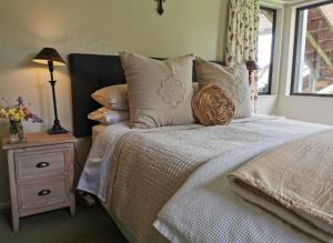 a bedroom with a bed and a night stand with a window at La Belle Vie Bed & Breakfast in Napier