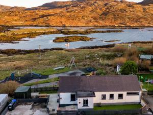 an aerial view of a house next to a body of water at Beinn Mhor View in Lochboisdale
