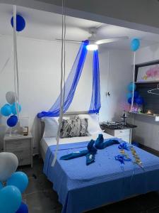 a bedroom with a bed with blue balloons on it at Tilys lodge in Capesterre-Belle-Eau