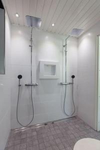 a white bathroom with a shower and a toilet at Tasokas ok-talo luonnon äärellä lähellä kaupunkia in Seinäjoki
