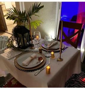 einen Tisch mit zwei Teller mit Speisen und Weingläsern in der Unterkunft Tilys lodge in Capesterre-Belle-Eau