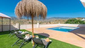 a patio with chairs and an umbrella and a swimming pool at Casa Rio Grande 2 Tolox by Ruralidays in Tolox