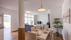 a dining room and living room with a table and chairs at Casa Rio Grande 2 Tolox by Ruralidays in Tolox