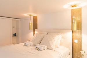 ein Schlafzimmer mit einem weißen Bett mit zwei Handtüchern darauf in der Unterkunft Luxury modern two bedroom duplex by Roland Garros in Paris