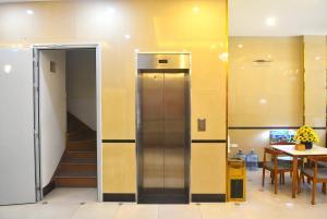 a elevator in a room with a table and chairs at Thanh Hang Hotel near Emerald My Dinh in Hanoi