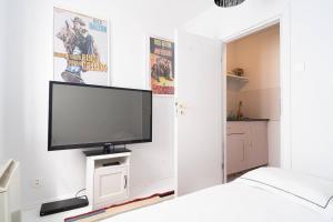 een slaapkamer met een flatscreen-tv aan de muur bij Tomte - scandinavian apartment in Krakau