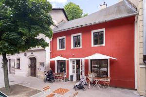 een rood gebouw met tafels en stoelen ervoor bij Tomte - scandinavian apartment in Krakau