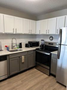 een keuken met roestvrijstalen apparatuur en witte kasten bij Beautiful Cozy Apartment ! in Oak Park