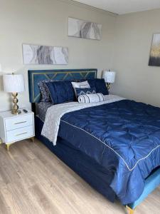 um quarto com uma cama azul e uma mesa de cabeceira em Beautiful Cozy Apartment ! em Oak Park