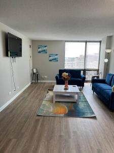 uma sala de estar com um sofá azul e uma mesa em Beautiful Cozy Apartment ! em Oak Park