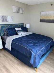 um quarto com uma cama azul e um edredão azul em Beautiful Cozy Apartment ! em Oak Park