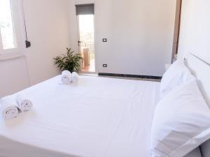 een witte slaapkamer met witte lakens en handdoeken op een bed bij The view in La Spezia