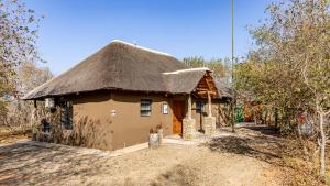 a small house with a thatched roof at Blue Goose Bush Retreat in Marloth Park