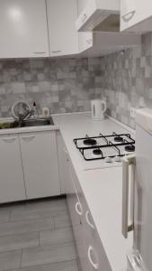 uma cozinha branca com um fogão e um lavatório em Metro La Salut em Badalona
