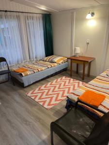 a room with three beds and a table in it at Ośrodek Wczasowy WARMA in Grudziądz