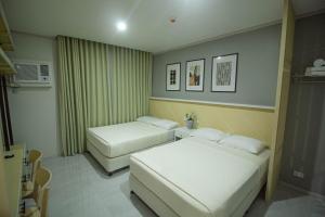 a hotel room with two beds and a microwave at Twin Hearts Residences 1 in Roxas City