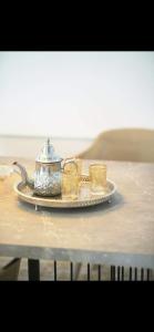 a tea kettle and two glasses on a plate on a table at Pristigia rabat in Rabat