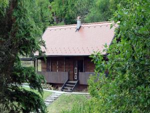 a wooden house with a red roof and a porch at Tradicionalna zagorska drvena kuća Stara murva in Tuheljske Toplice