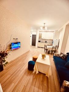 Label Apartment في تبليسي: غرفة معيشة مع أريكة زرقاء وطاولة