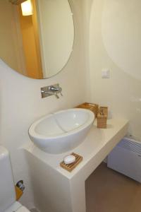 y baño con lavabo blanco y espejo. en Miss Valentina-Modern Stone Villa in Aegina en Aegina Town