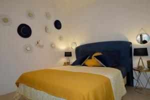 a bedroom with a bed with a blue head board at Miss Valentina-Modern Stone Villa in Aegina in Aegina Town