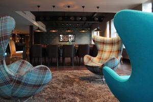 a restaurant with a bar with chairs and a table at Motel One Edinburgh-Princes in Edinburgh