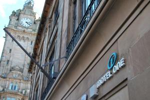 a sign on a building with a clock tower at Motel One Edinburgh-Princes in Edinburgh