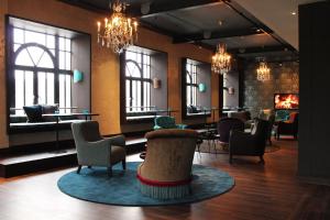a lobby with chairs and tables and windows at Motel One Edinburgh-Princes in Edinburgh
