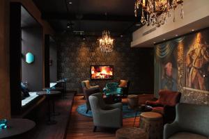 a lobby with chairs and a fireplace and a chandelier at Motel One Edinburgh-Princes in Edinburgh