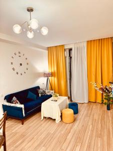 Label Apartment في تبليسي: غرفة معيشة مع أريكة زرقاء وطاولة