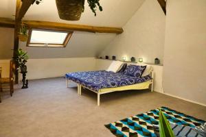 een slaapkamer met een bed in de hoek van een kamer bij Villa Capucine in Aubigny-sur-Nère
