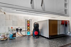 a kitchen counter with a microwave on a counter top at Free Parking Near Shelly Beach Holiday Home in Exeter