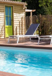 a bench next to a swimming pool next to a house at Maison et table d'hôtes Le Camélia Blanc in Saint-Ciers-sur-Gironde