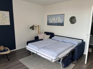 Bett in einem Zimmer mit blauem Bettrahmen in der Unterkunft Ferienwohnung Fördedeck in Kiel