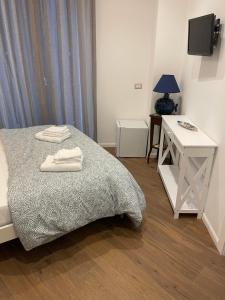 a bedroom with a bed and a desk and a television at B&B Vietri Centro 2 in Vietri sul Mare