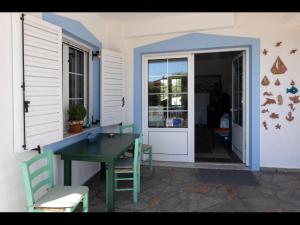 un patio con mesa y sillas junto a una puerta en Papoulias Rooms en Elafonisos