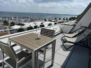 einen Tisch und Stühle auf einem Balkon mit Blick auf das Wasser in der Unterkunft Ferienwohnung Fördedeck in Kiel