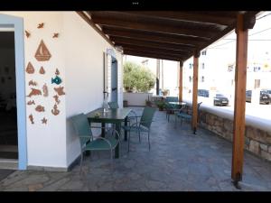 a patio with a table and chairs on a building at Papoulias Rooms in Elafonisos +16 photos