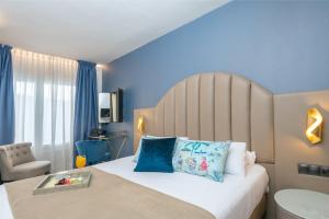 a bedroom with a large bed with blue walls at Hotel Palacete de Alamos in Málaga