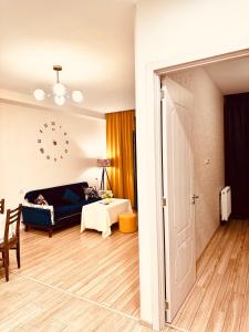 Label Apartment في تبليسي: غرفة معيشة بها سرير وساعة على الحائط