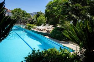 a large swimming pool with chairs and palm trees at Villa w Pool and Balcony 3 min to Dalyan River in Ortaca