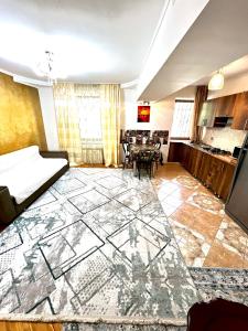 ein Wohnzimmer mit großem Fliesenboden und eine Küche in der Unterkunft Уютная евро двушка в центре Алматы #57 in Almaty
